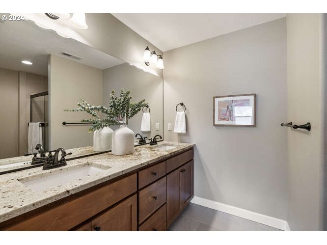 4307 Northwest Sage Loop Camas, WA 98607 - Photo 26 of 40 a bathroom with a granite countertop sink a mirror and a shower