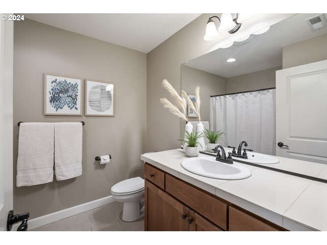4307 Northwest Sage Loop Camas, WA 98607 - Photo 33 of 40 a bathroom with a sink a toilet and mirror