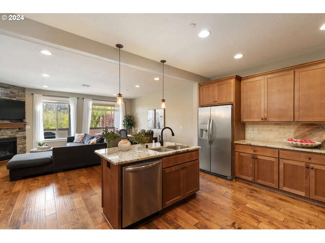 4307 Northwest Sage Loop Camas, WA 98607 - Photo 5 of 40 a kitchen with stainless steel appliances granite countertop a sink a stove and refrigerator