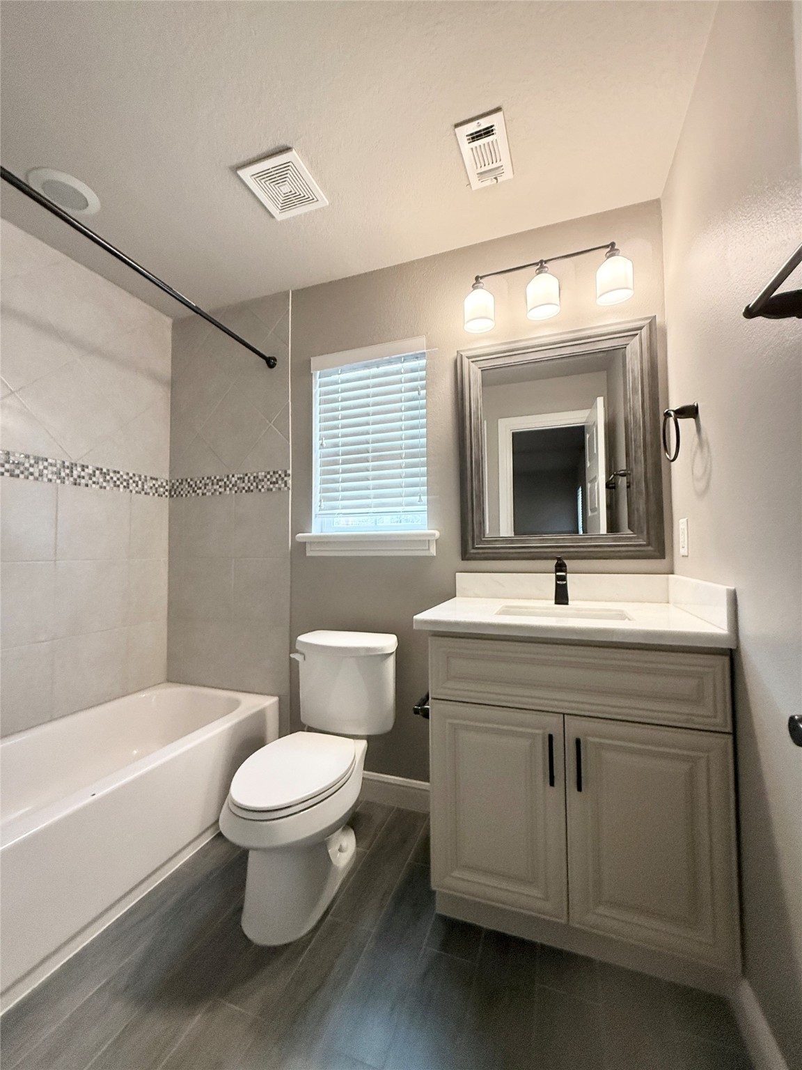 2116 Couch Street Houston, TX 77008 - Photo 41 of 43 a bathroom with a toilet a sink a mirror a bathtub and shower