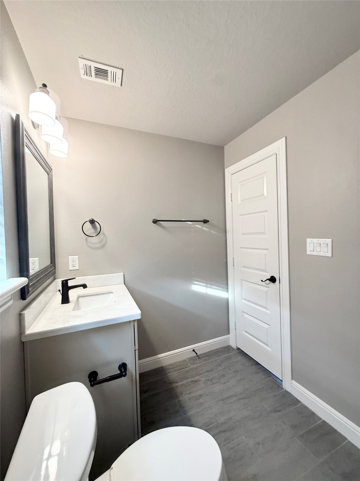 2116 Couch Street Houston, TX 77008 - Photo 42 of 43 a bathroom with a toilet a sink and mirror