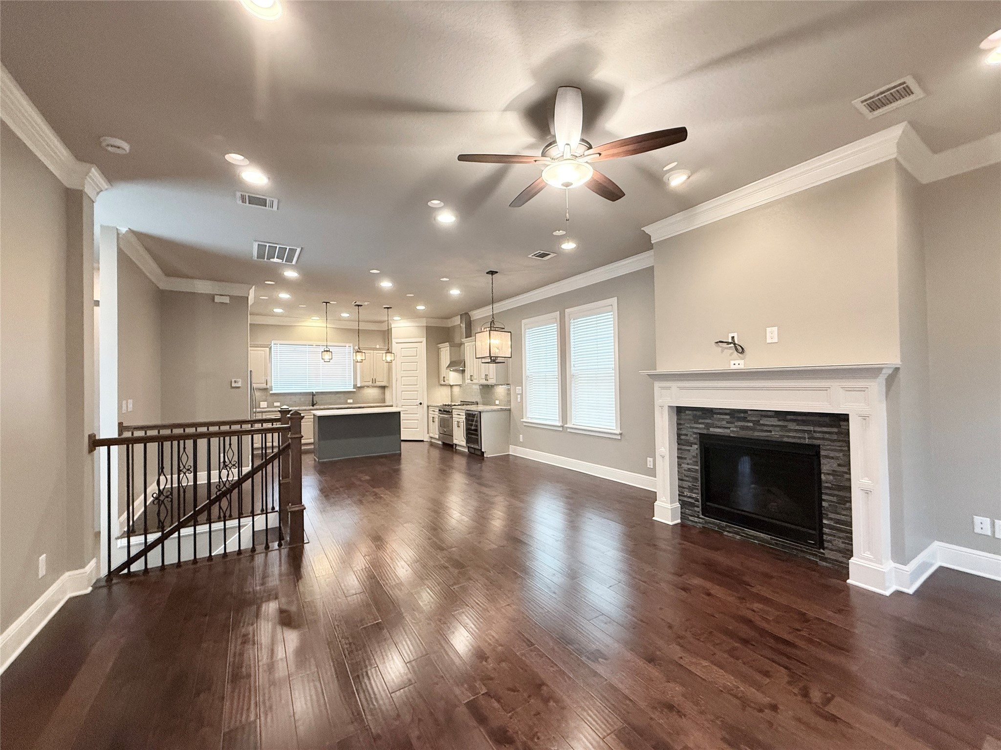 2116 Couch Street Houston, TX 77008 - Photo 7 of 43 a view of a livingroom with a fireplace a chandelier fan wooden floor and a kitchen