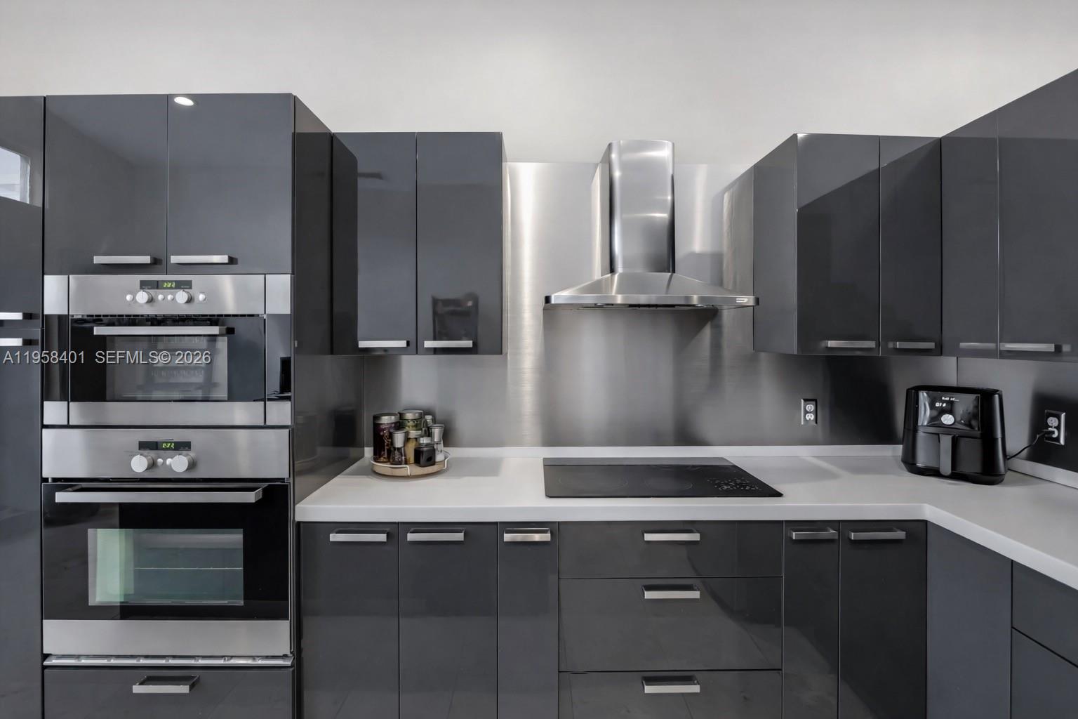 17476 Southwest 20th Street Miramar, FL 33029 - Photo 5 of 28 a kitchen with stainless steel appliances a sink a stove a microwave a sink and cabinets