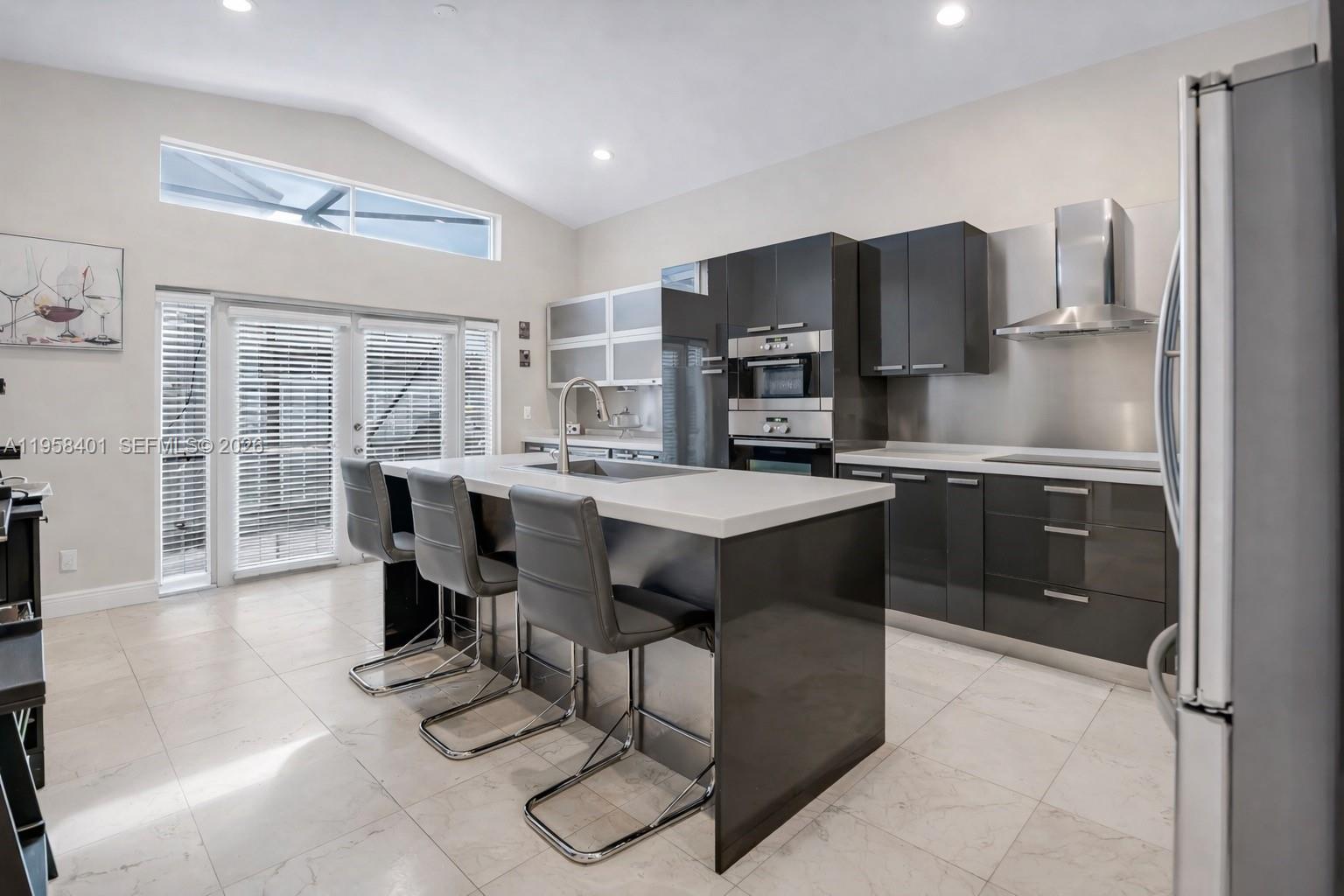 17476 Southwest 20th Street Miramar, FL 33029 - Photo 7 of 28 a kitchen with stainless steel appliances a sink a stove a refrigerator cabinets and a dining table