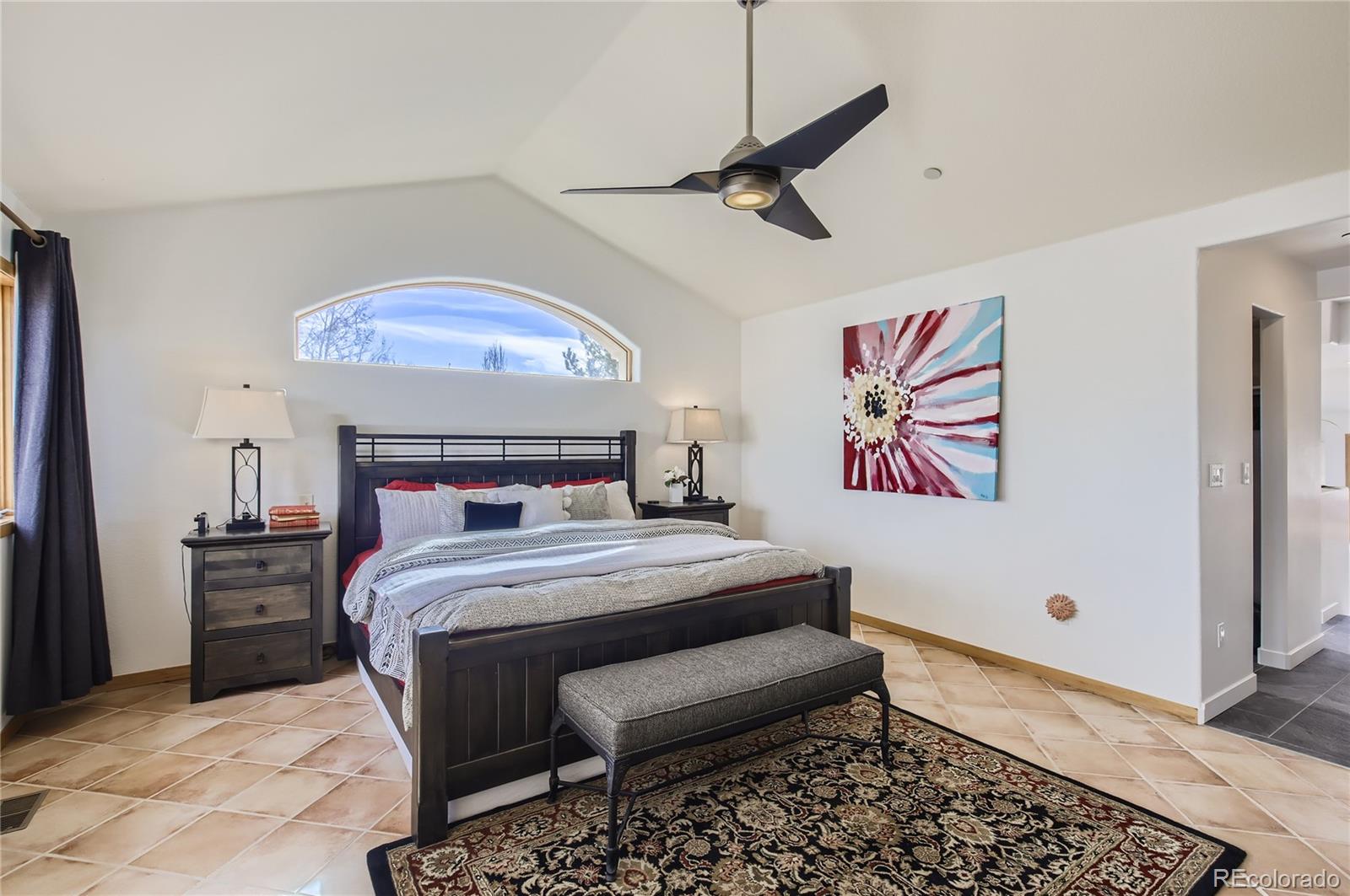 7578 Crestview Drive Niwot, CO 80504 - Photo 15 of 40 a bedroom with a bed and a chandelier