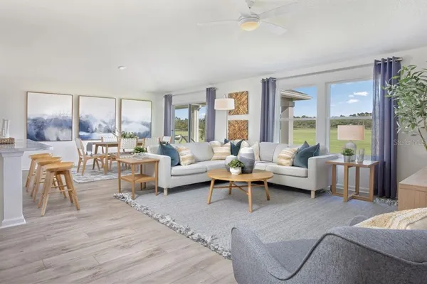 a kitchen with stainless steel appliances a dining table chairs refrigerator and microwave