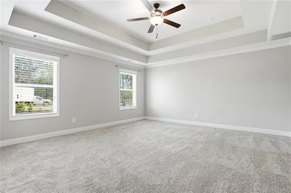 an empty room with windows and fan