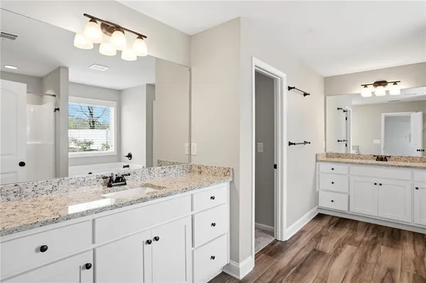 a spacious bathroom with a granite countertop sink a mirror a vanity and a