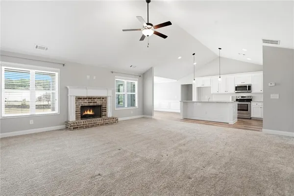 a view of empty room with a kitchen stove and a fireplace