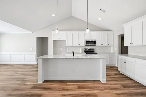 a kitchen with stainless steel appliances granite countertop a stove a sink and a refrigerator
