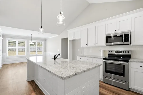 a kitchen with stainless steel appliances granite countertop a sink and a stove
