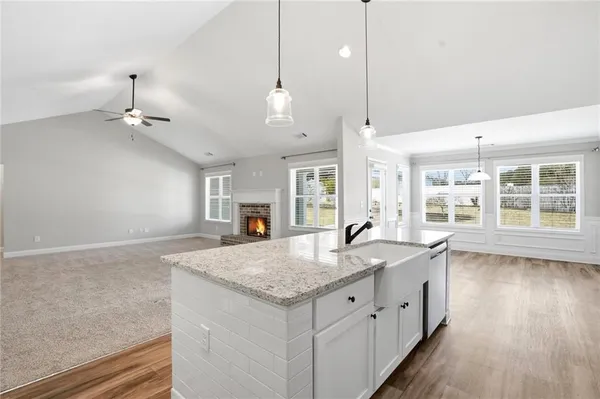 a kitchen with granite countertop a sink a center island and wooden floor