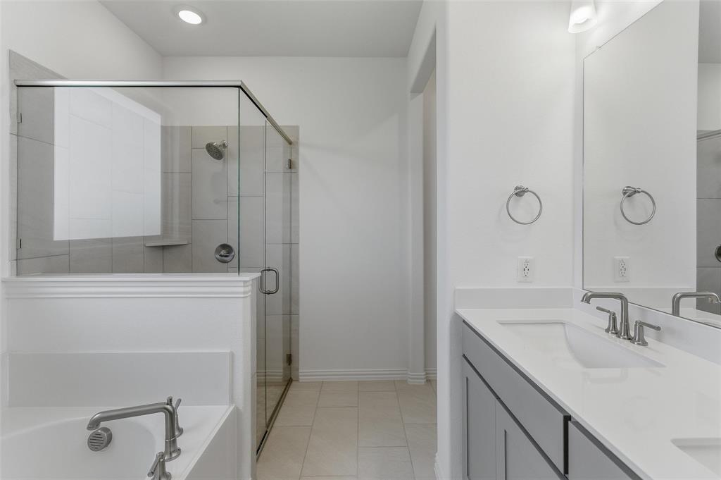 130 Fossil Canyon Drive Rhome, TX 76078 - Photo 18 of 25 Contemporary bathroom featuring a dual vanity with rectangular undermount sinks, brushed nickel faucets, and a large mirror