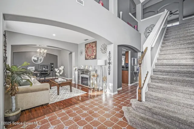 a living room with furniture a chandelier and a fireplace