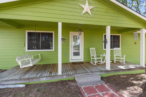 an empty room with ceiling fan and windows