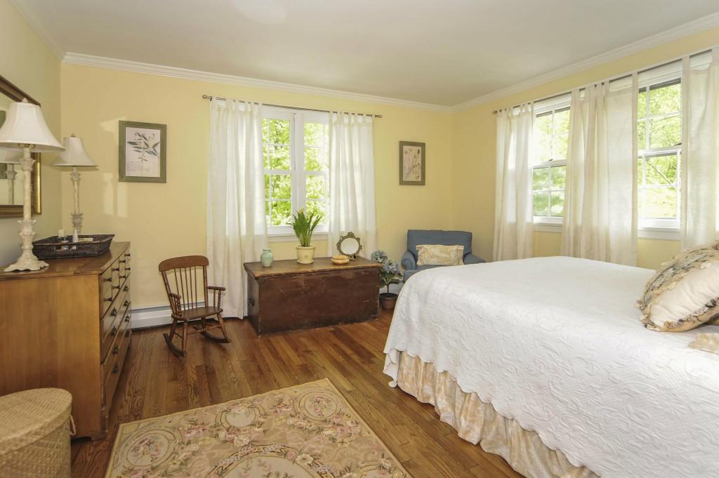 719 Cheese Spring Road New Canaan, CT 06840 - Photo 17 of 24 a large bedroom with a bed and wooden floor