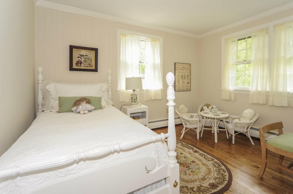 719 Cheese Spring Road New Canaan, CT 06840 - Photo 18 of 24 a spacious bedroom with a bed a table and chair