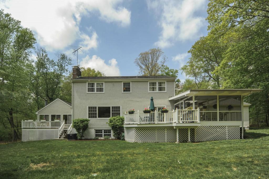 719 Cheese Spring Road New Canaan, CT 06840 - Photo 22 of 24 a front view of a house with a yard table and chairs