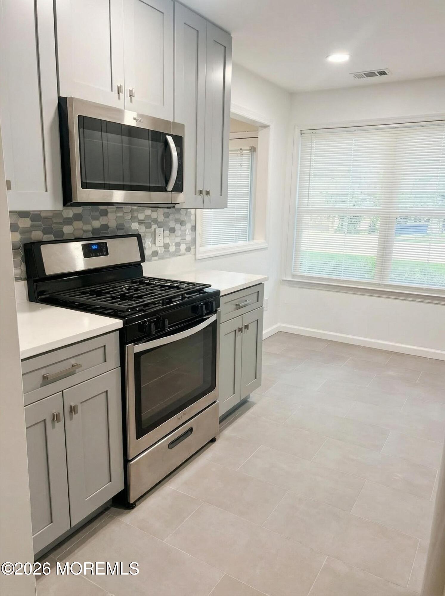 345 Sequoia Court Howell, NJ 07731 - Photo 2 of 4 a kitchen with stainless steel appliances granite countertop a stove a microwave a sink and cabinets