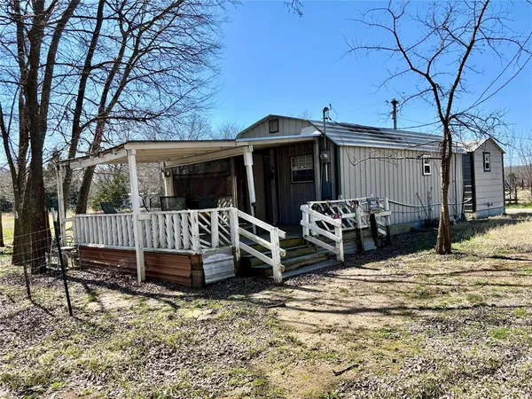 a view of a house with backyard and a tree