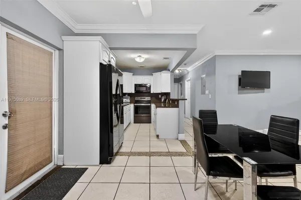 a view of kitchen with cabinets and refrigerator