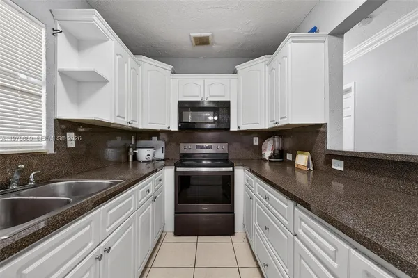a kitchen with granite countertop a sink and cabinets