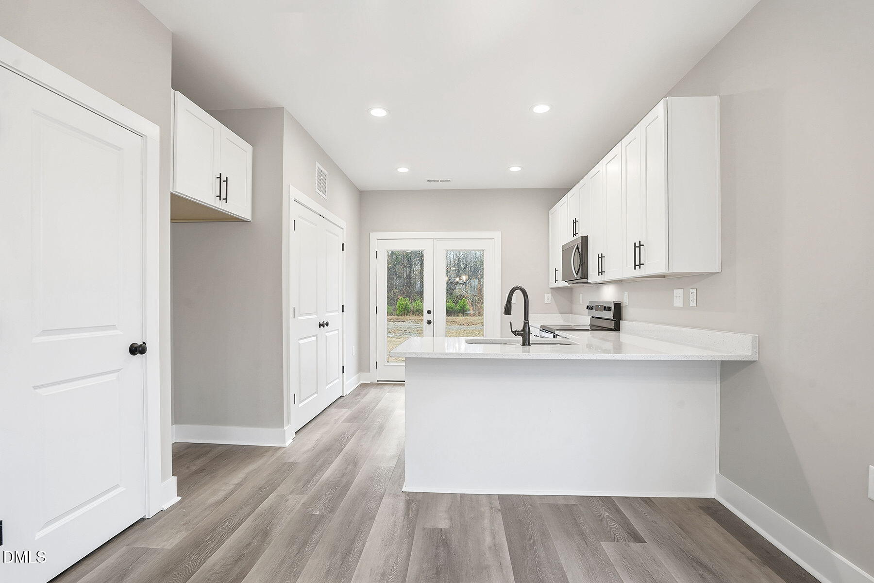 1029 Jada Allen Road Dunn, NC 28334 - Photo 10 of 31 a large white kitchen with wooden floor and a window