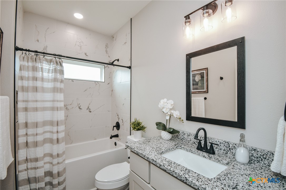 321 Whitetail Lane Victoria, TX 77905 - Photo 25 of 47 a bathroom with a granite countertop sink toilet tub and shower