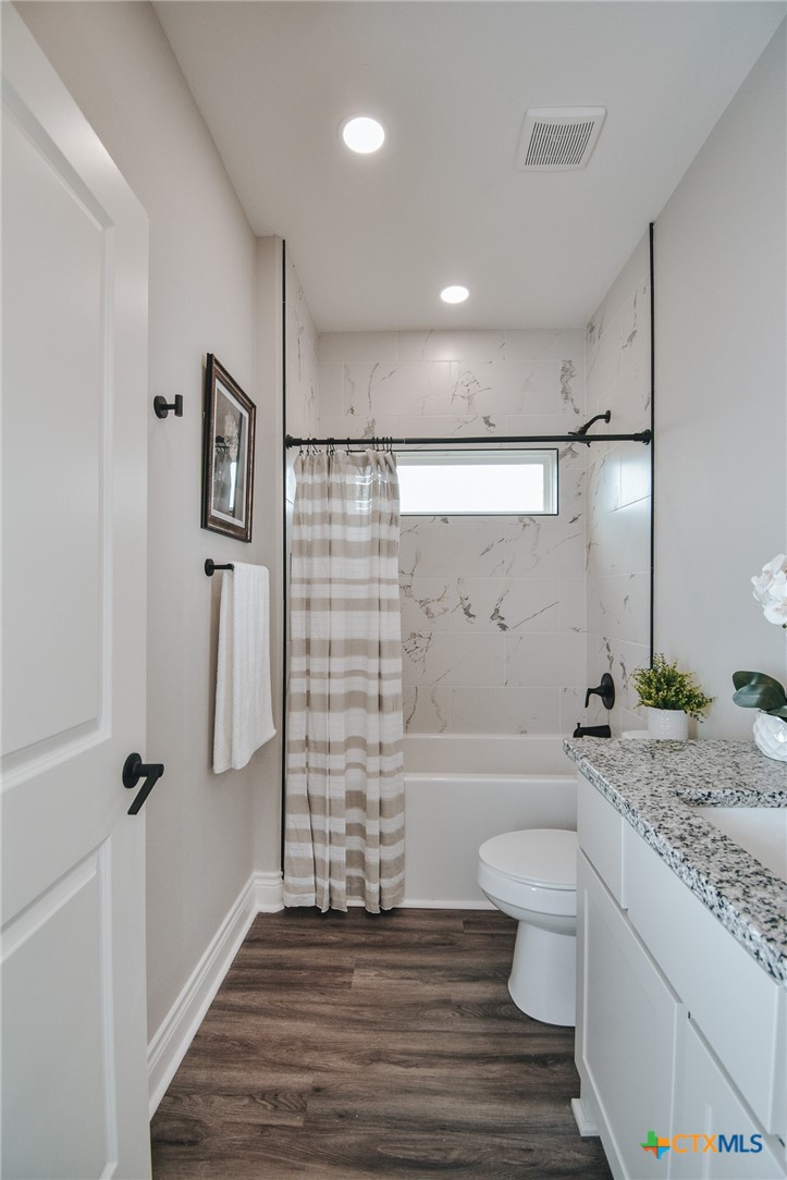 321 Whitetail Lane Victoria, TX 77905 - Photo 26 of 47 a bathroom with a granite countertop toilet a sink and bathtub