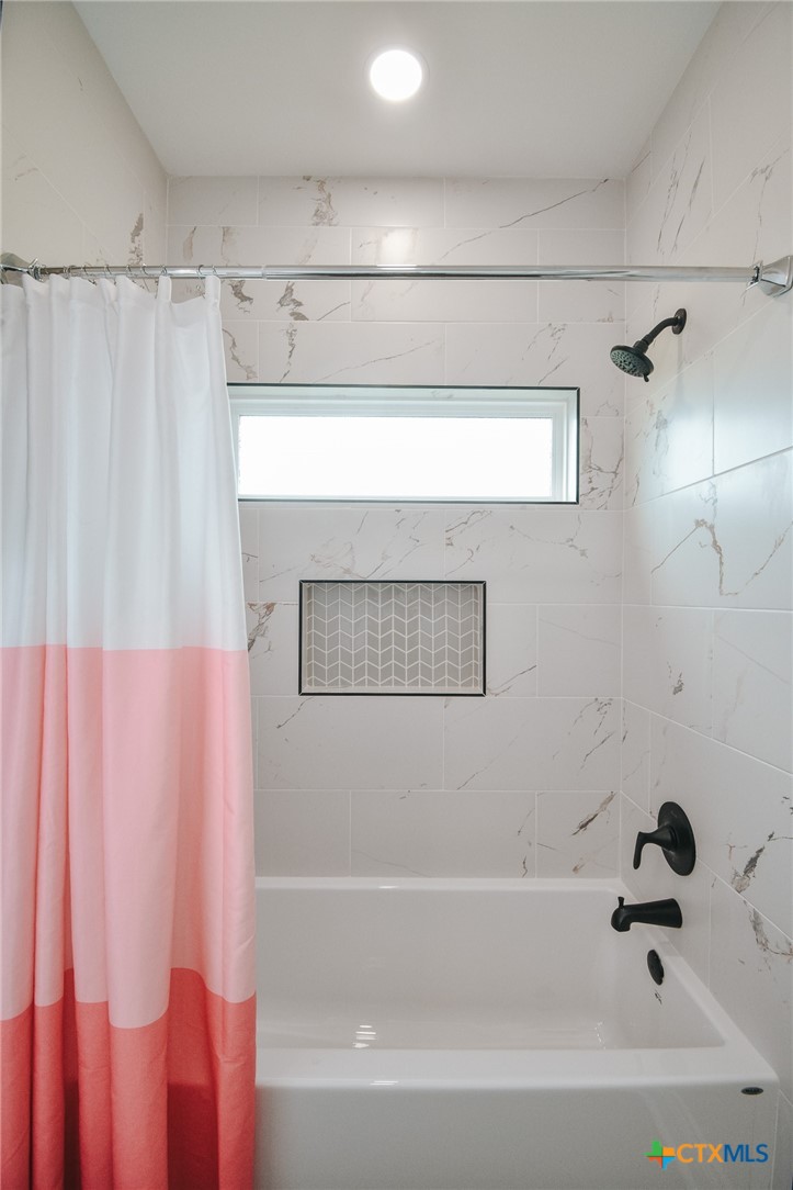 321 Whitetail Lane Victoria, TX 77905 - Photo 31 of 47 a bathroom with a bathtub a shower and a shower curtain