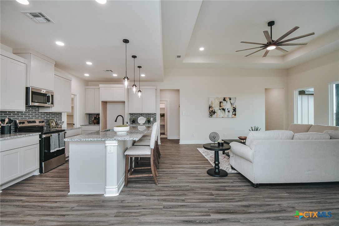 321 Whitetail Lane Victoria, TX 77905 - Photo 5 of 47 a living room with stainless steel appliances kitchen island granite countertop a dining table chairs refrigerator and sink