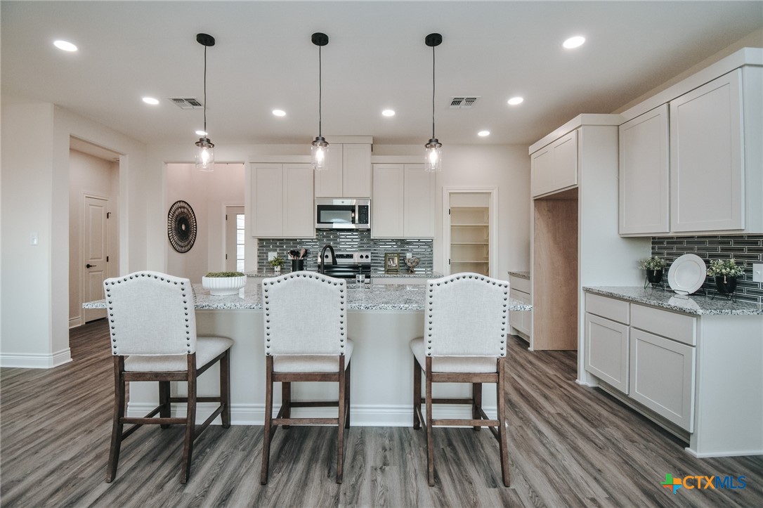 321 Whitetail Lane Victoria, TX 77905 - Photo 6 of 47 a kitchen with kitchen island stainless steel appliances a dining table chairs sink and microwave