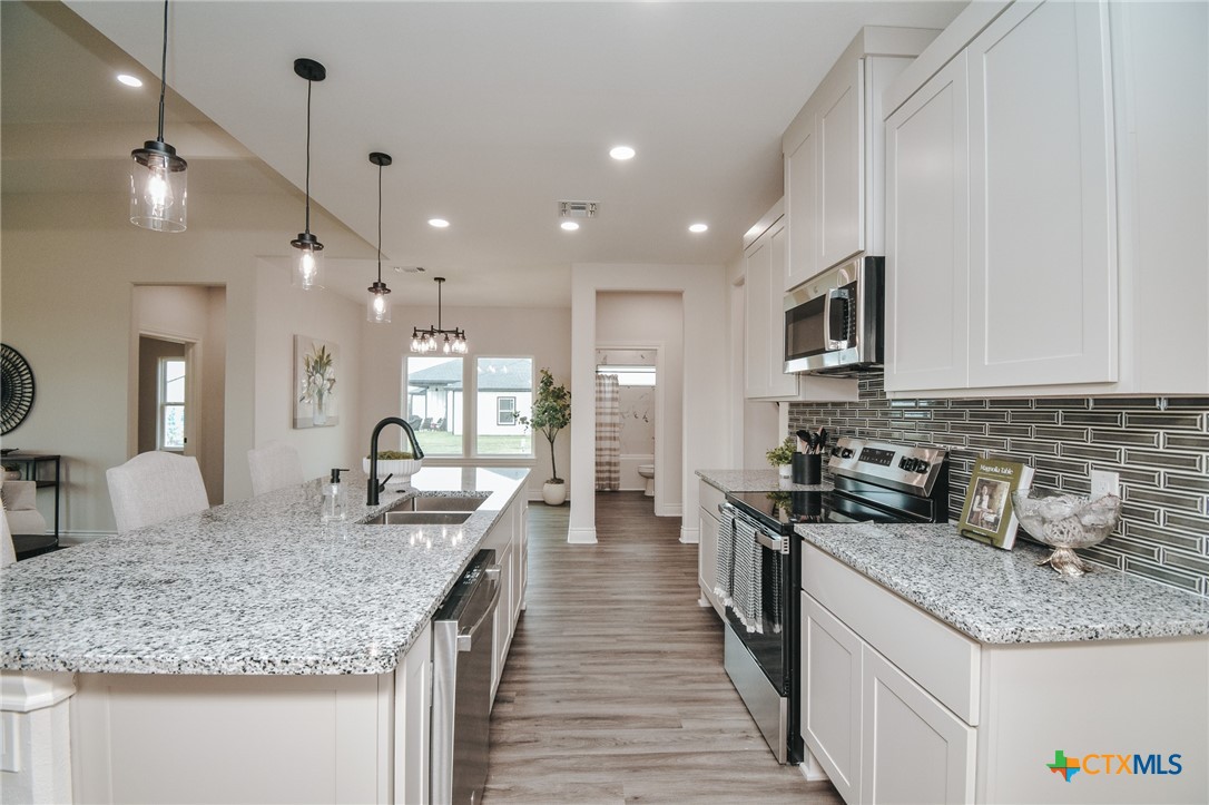 321 Whitetail Lane Victoria, TX 77905 - Photo 9 of 47 a kitchen with granite countertop kitchen island a sink and a stove top oven