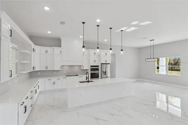 a large white kitchen with a large window
