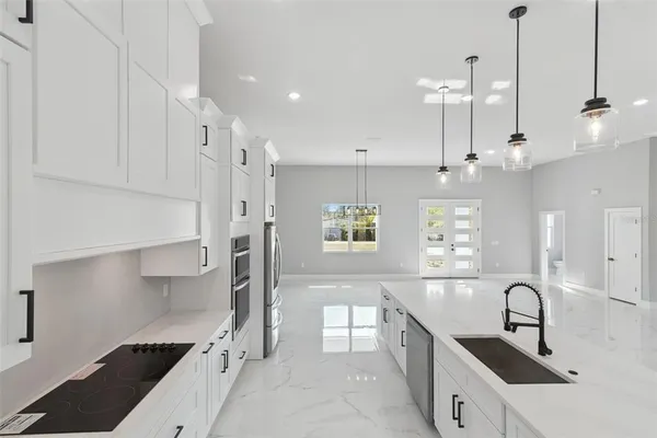 a kitchen with stainless steel appliances a sink a stove a refrigerator and window