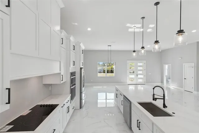 a kitchen with stainless steel appliances a sink a stove a refrigerator and window