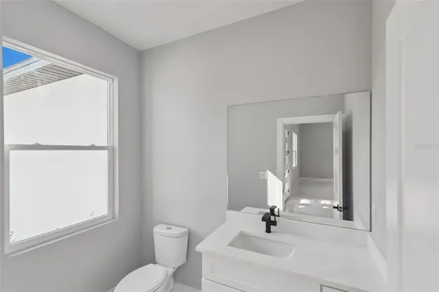 a bathroom with a toilet a sink and mirror