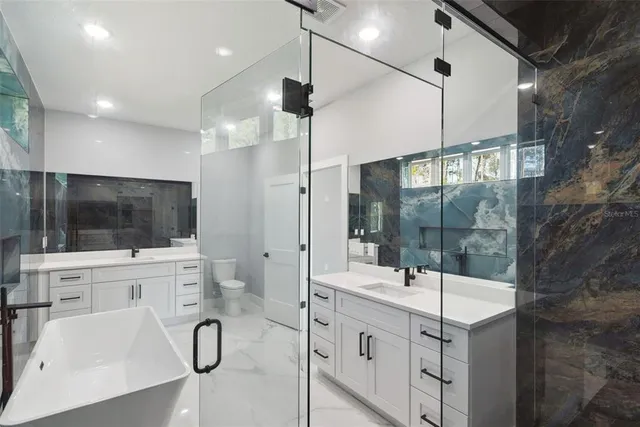 a bathroom with a double vanity sink a mirror and shower
