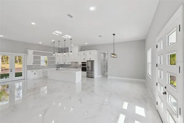 a view of a kitchen with kitchen island wooden floor center island and stainless steel appliances