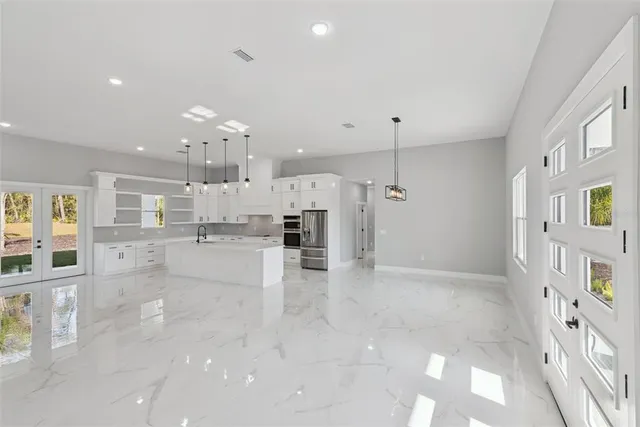 a view of a kitchen with kitchen island wooden floor center island and stainless steel appliances