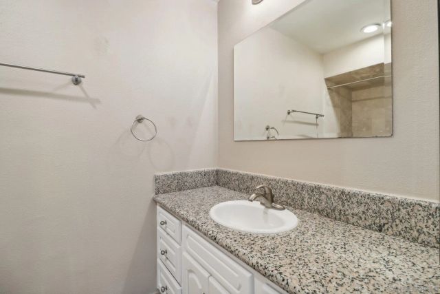 a kitchen with kitchen island a stove a sink a refrigerator and white cabinets with wooden floor