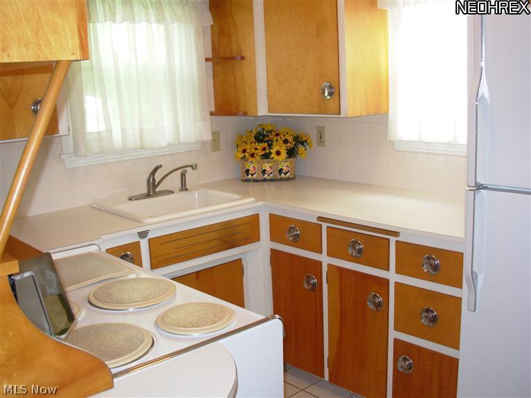 Retro economy kitchen with stove and refrigerator.