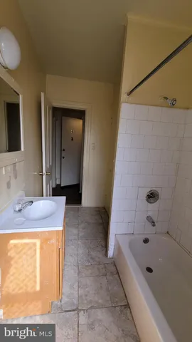 a bathroom with a granite countertop sink and a bathtub