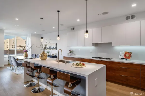 a kitchen with kitchen island a stove a table and chairs in it