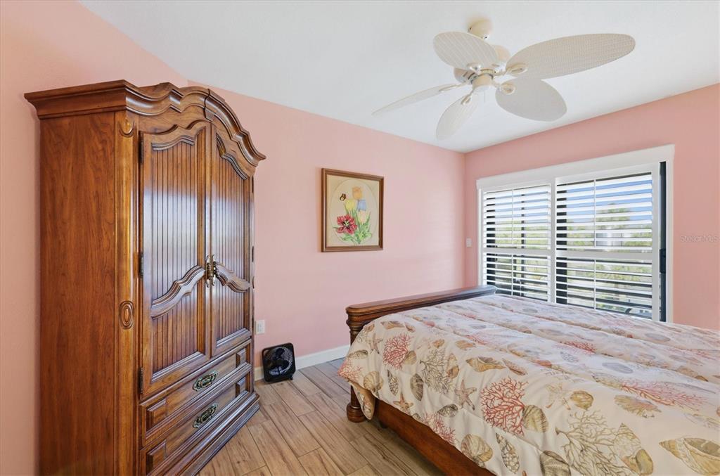2729 North Beach Road, Unit 211 Englewood, FL 34223 - Photo 30 of 51 a bedroom with a bed and a chandelier