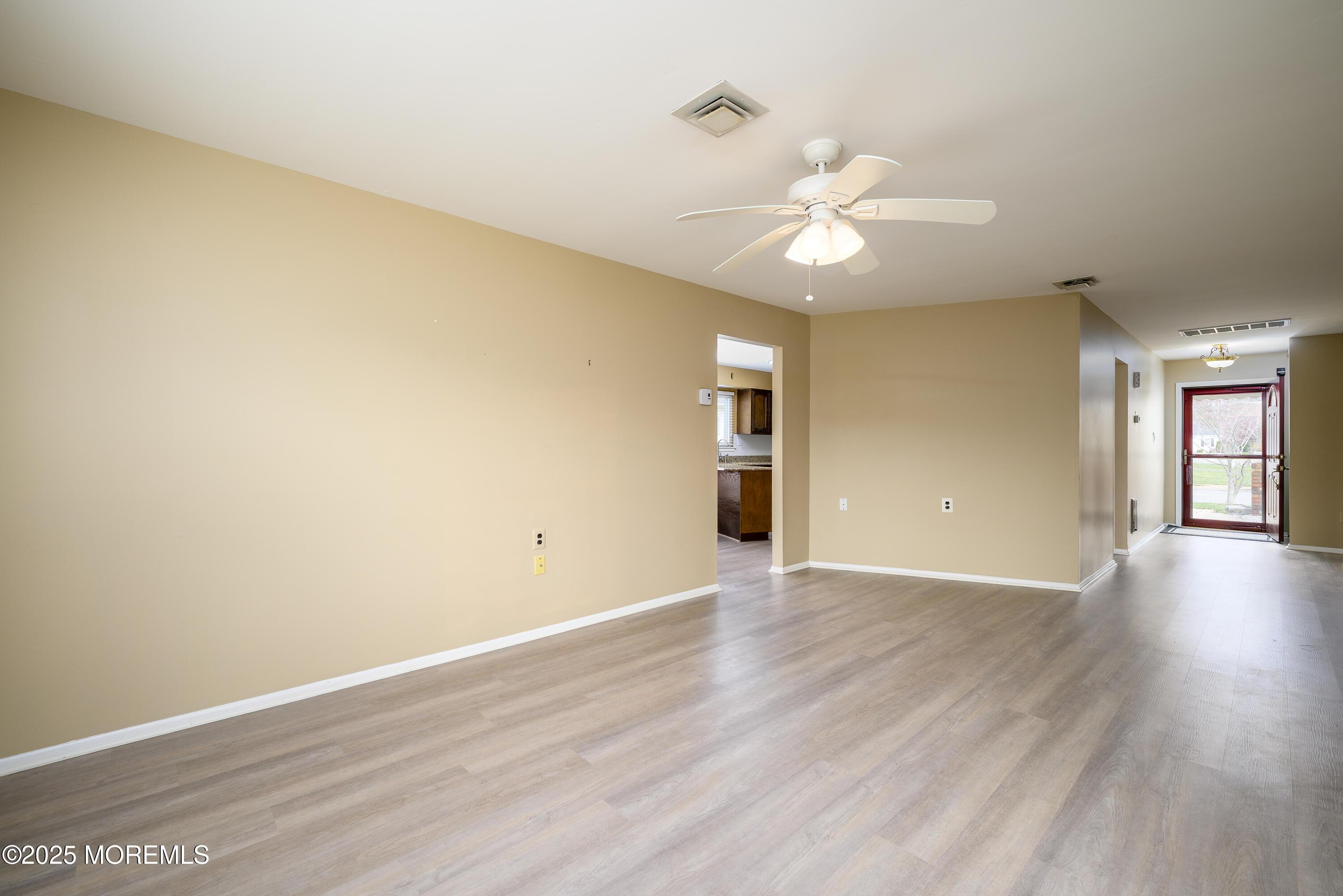 27 Blake Circle Brick, NJ 08724 - Photo 7 of 39 an empty room with wooden floor chandelier fan and windows
