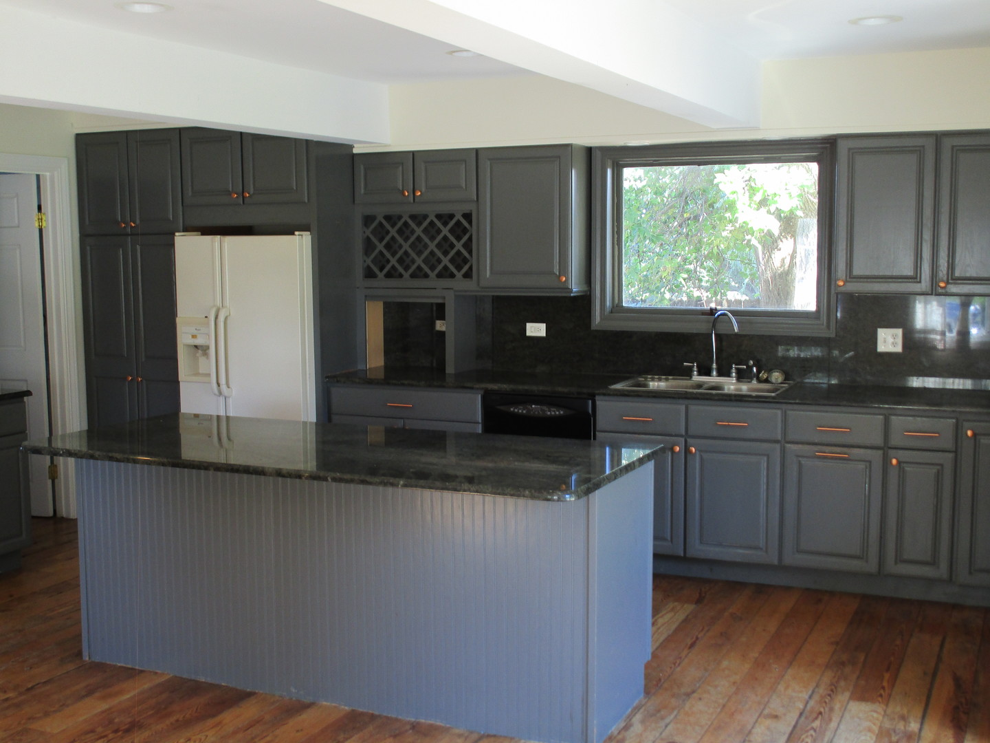 19882 McGuire Road Harvard, IL 60033 - Photo 11 of 17 a kitchen with kitchen island granite countertop a sink cabinets and wooden floor