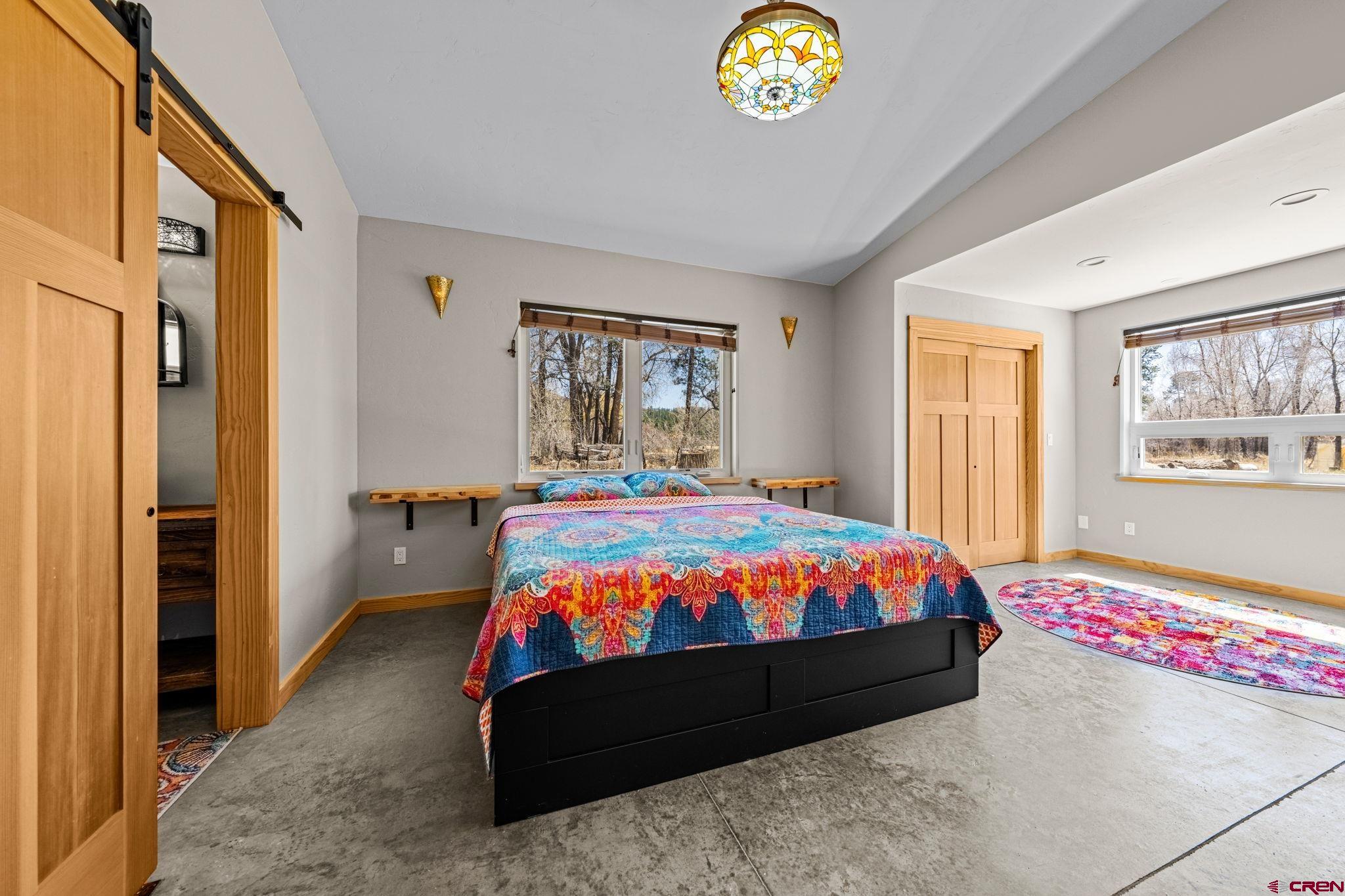 124 Richards Drive Bayfield, CO 81122 - Photo 16 of 42 a bedroom with a bed and a chandelier