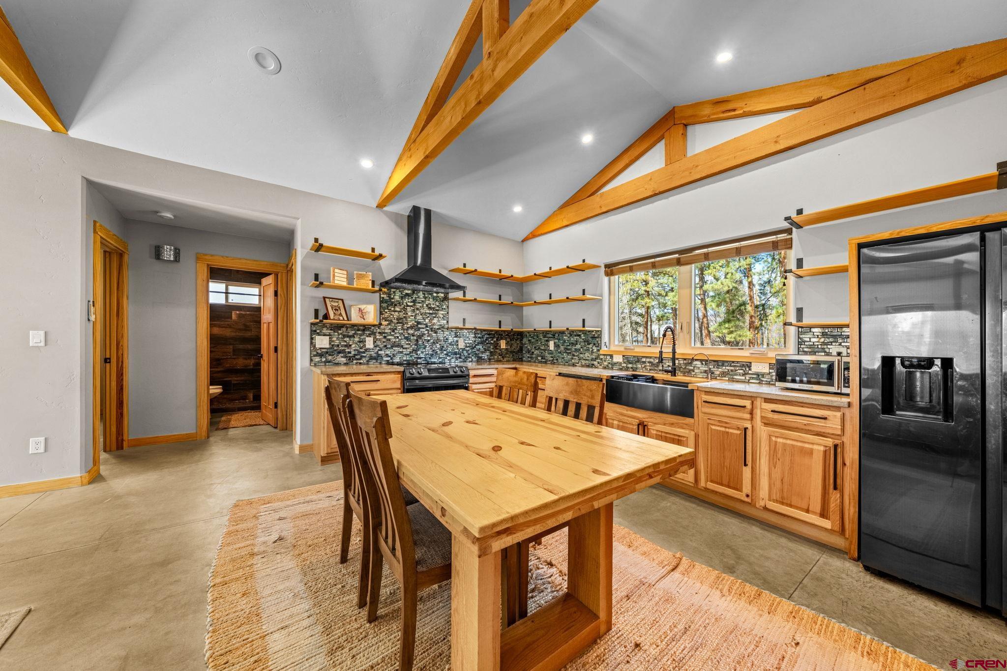124 Richards Drive Bayfield, CO 81122 - Photo 7 of 42 a kitchen with a table chairs refrigerator and cabinets