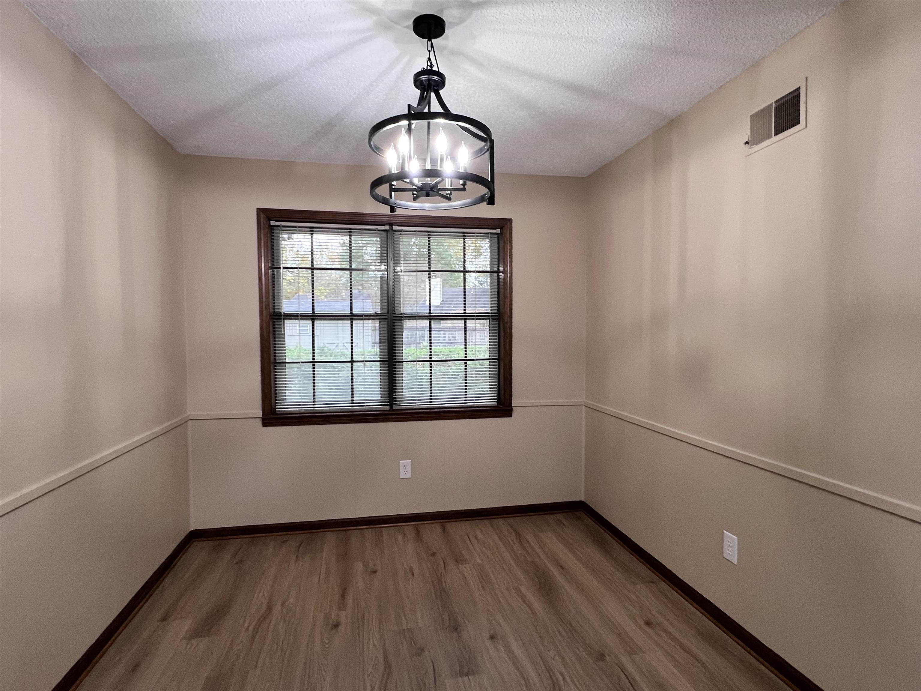 309 West Powell Road Collierville, TN 38017 - Photo 11 of 40 a view of an empty room with wooden floor and a window